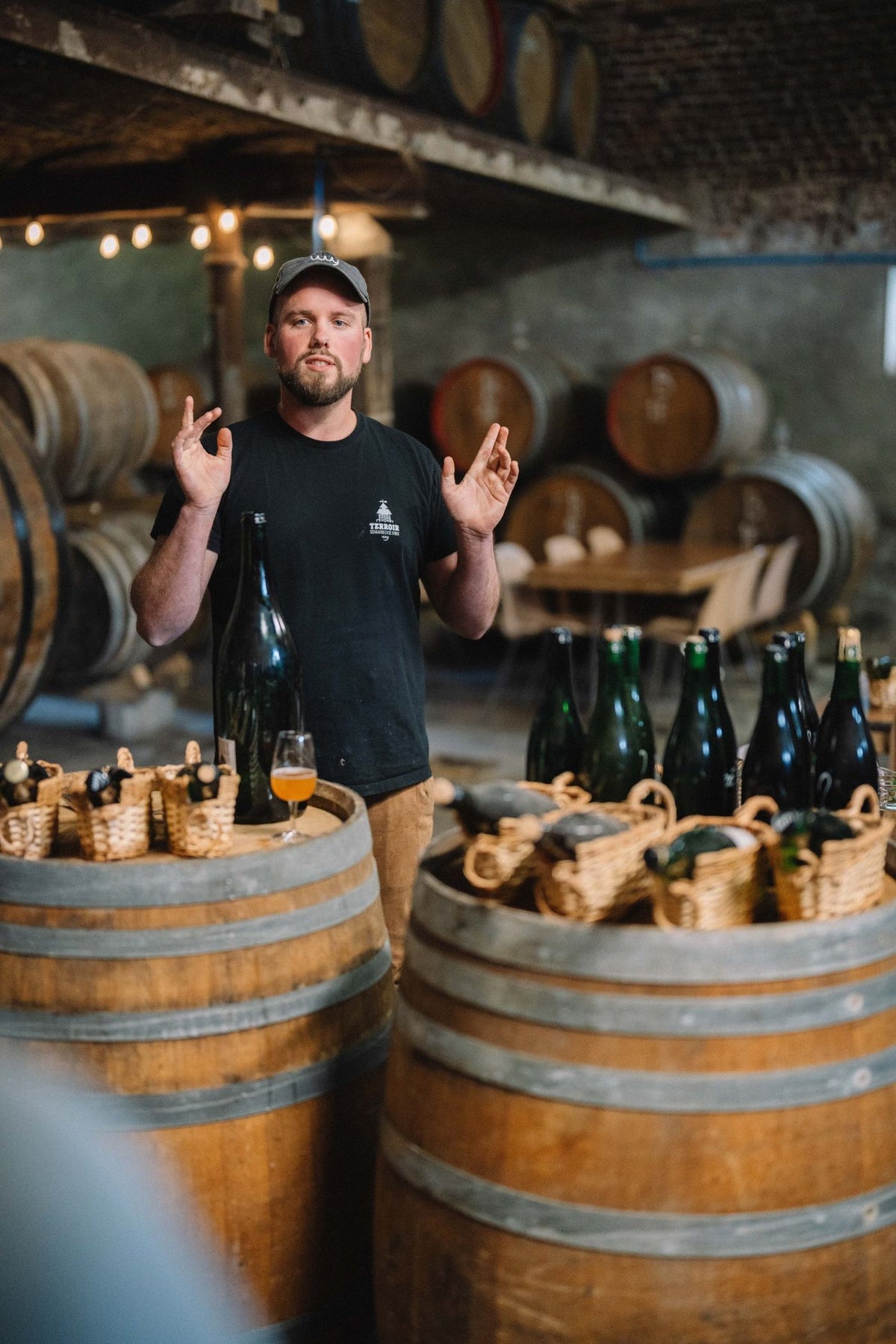 Senne, brouwer van Boerenerf, legt lambiek en geuze uit tussen de houten vaten