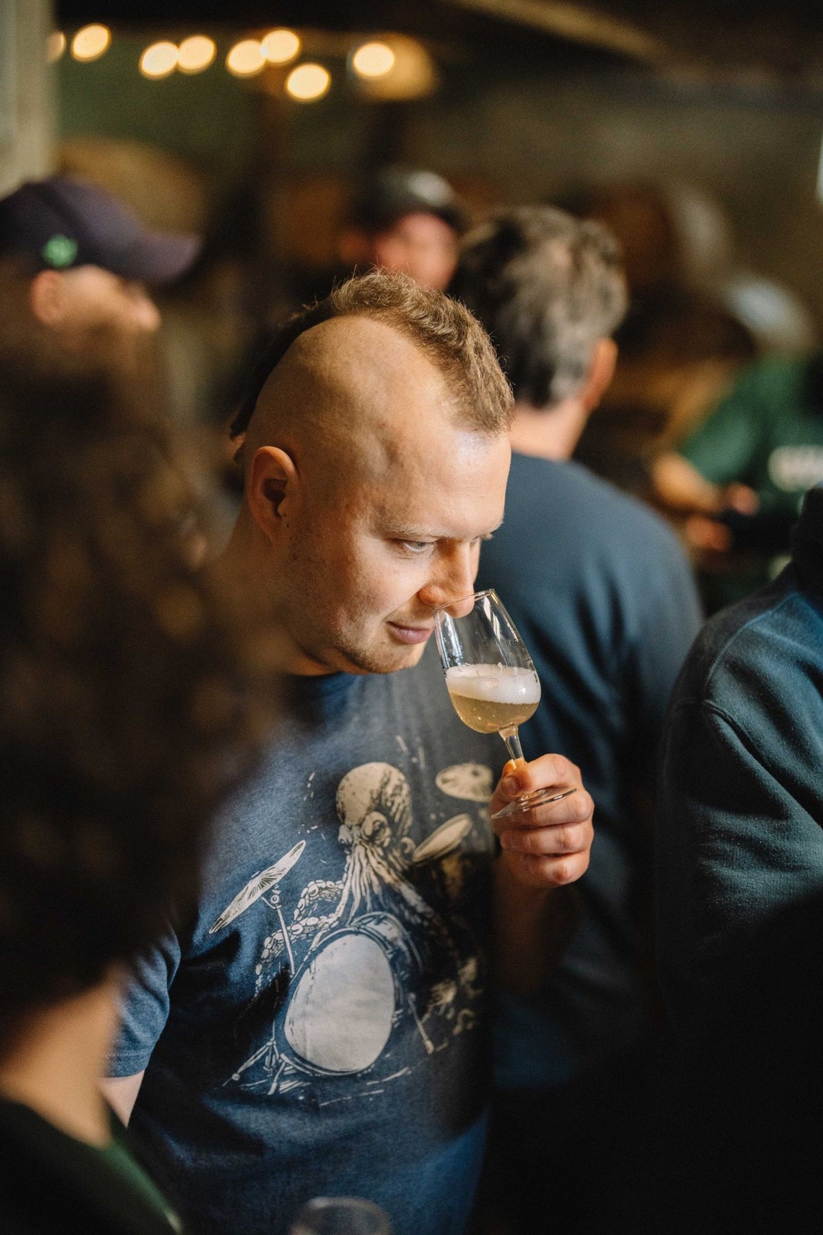 Gast ruikt aan een glas geuze tijdens de masterclass van Boerenerf